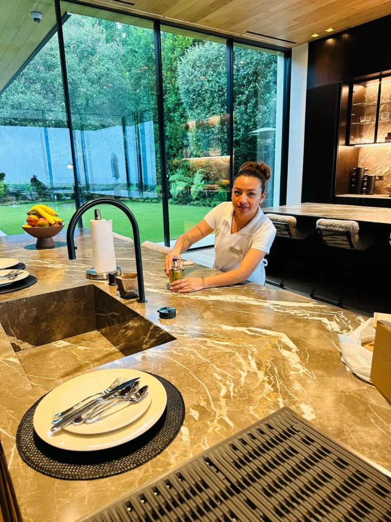 FJ Luxury Services housekeeper detailing a marble kitchen island in a luxury Los Angeles home