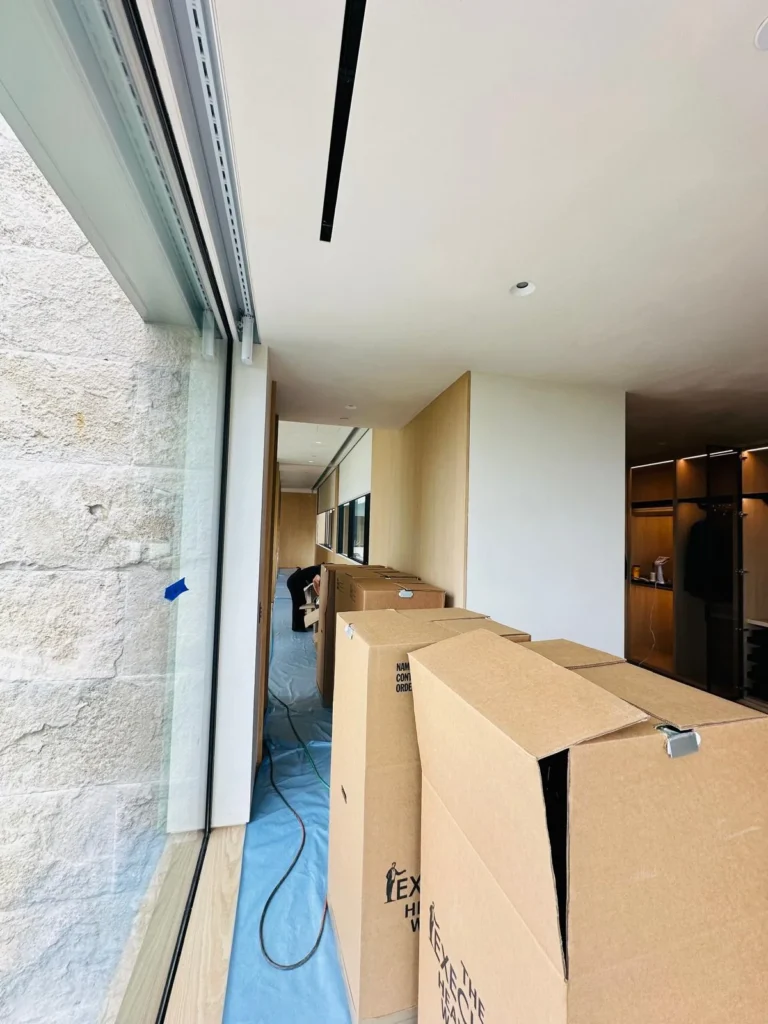 Moving boxes staged along a protected hallway during a move-in service at a Los Angeles luxury estate